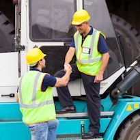 Supervisor recognizing heavy equipment operator by shaking hands