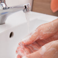 Worker washing hands with soap and water
