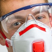 Worker wearing eye protection and face mask
