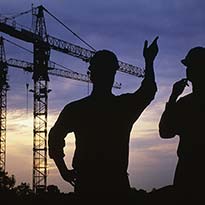Two workers discussing tower cranes in operations