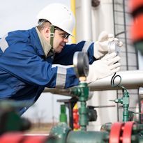 Woker inspecting oil pipeline pressure